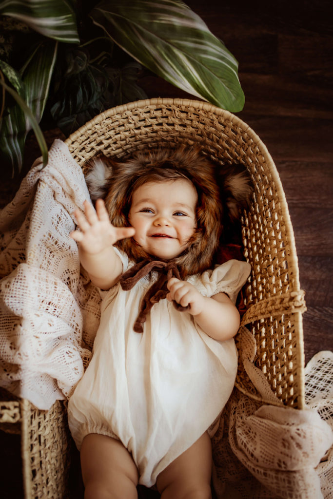 London Family Photographer, baby in Moses basket reaching their hand toward the camera