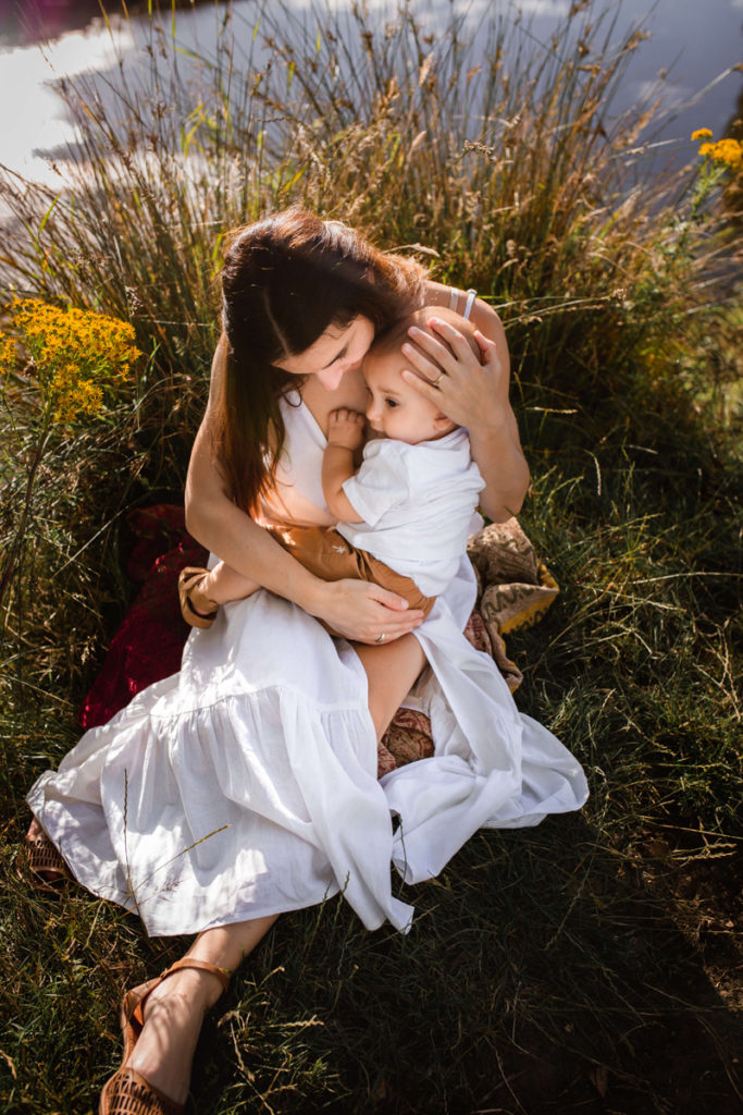 London Family Photographer, mother sitting down and cuddling her baby boy close to her chest